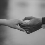 monochrome photo of couple holding hands